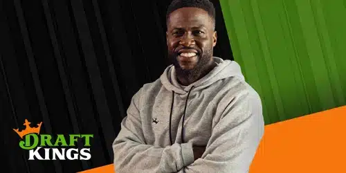 Kevin Hart smiling and wearing a gray hoodie with his arms crossed. The DraftKings logo is visible in the bottom left corner. The background features a split design with black stripes on the left and green stripes on the right, meeting an orange diagonal stripe at the bottom